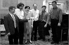 The group holds up an index card serving as the band sign at the Bullin wedding